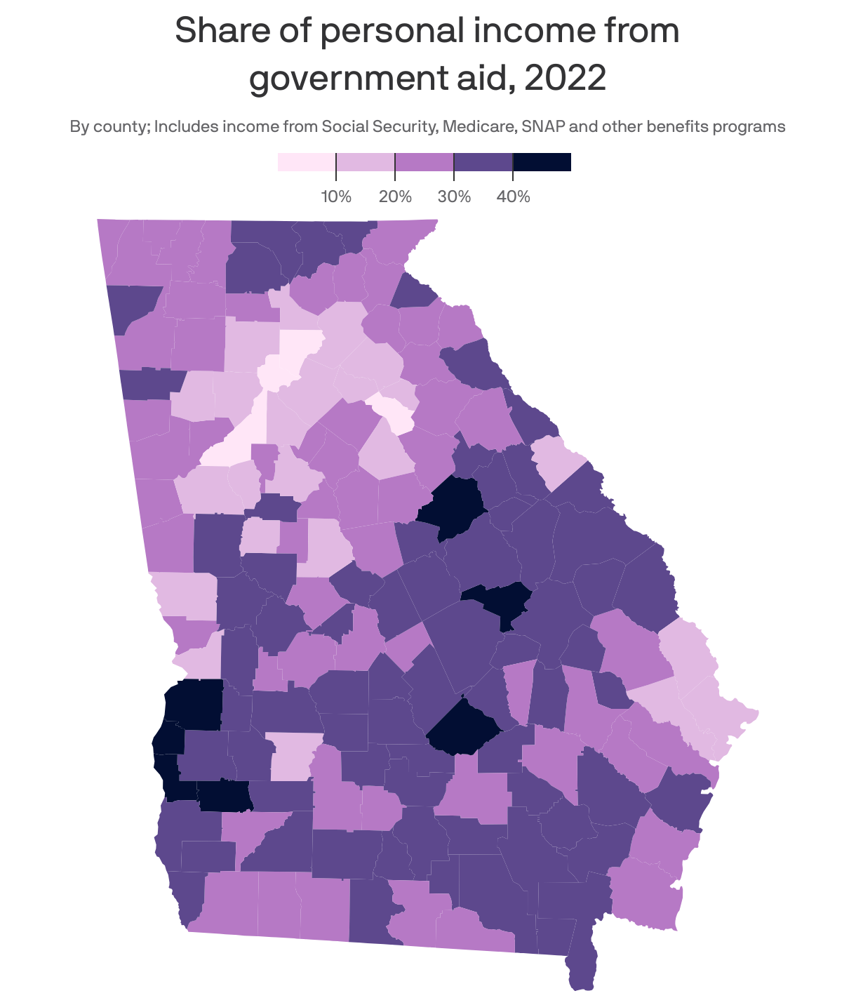 Choropleth map of U.S. counties showing the share of total personal income coming from government aid in 2022. Overall, counties in the Southern U.S., as well as rural counties, had a higher reliance on benefits programs like Social Security and Medicare compared to counties in the Northeast and Rust Belt. West Virginia counties had the highest average share, at 25.4%, while Connecticut had the lowest, at 12%. Georgia had an average of 20%.